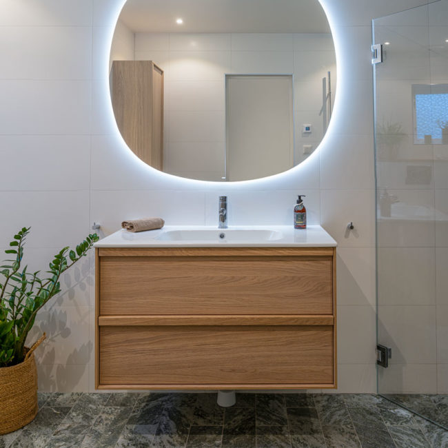 Renoverat badrum – kommod med lysande spegel över